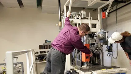 Two people inspecting machinery